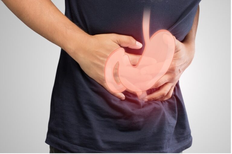A close-up shot of a man holding his stomach as he stuffers from Gastroparesis