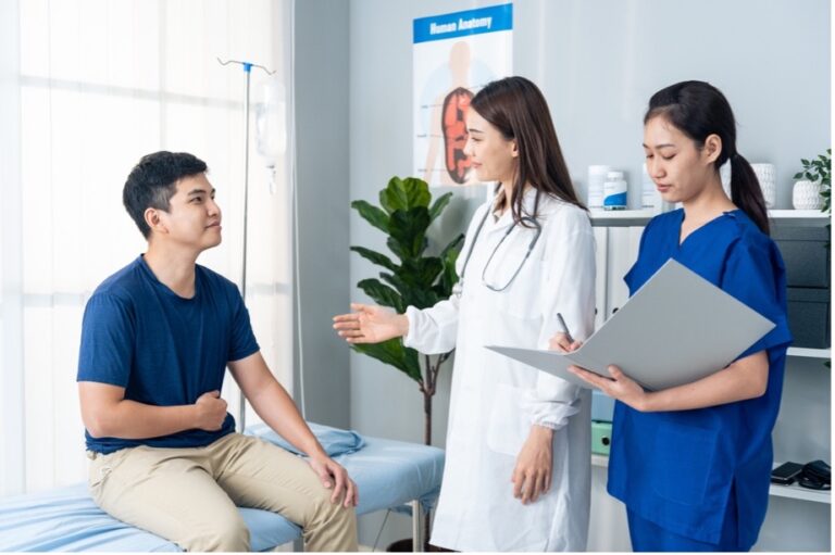 A female specialist doctor and nurse assist a male patient who suffers from rectal prolapse. Explaining to the patient the causes and symptoms of rectal prolapse Image Caption: Diagnoses and advice service treatment
